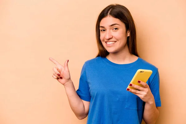 휴대폰을 코카서스 여성은 공간에서 무언가를보여 주면서 웃으면서 가리켰다 — 스톡 사진