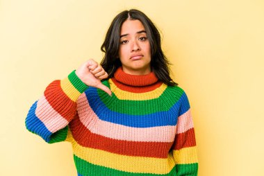 Sarı arka planda izole edilmiş genç İspanyol kadın hoşlanmadığı bir hareket gösteriyor. Anlaşmazlık konsepti.