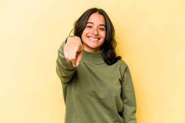 Sarı arka planda izole edilmiş genç İspanyol kadın. Önü işaret eden neşeli gülümsemeler..