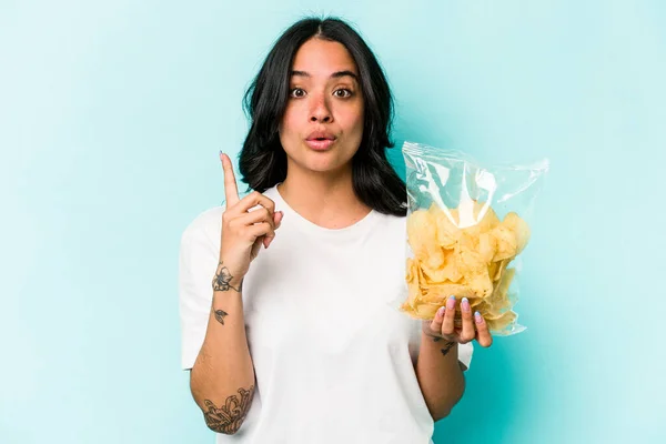 Ung Latinamerikansk Kvinna Håller Påse Chips Isolerad Blå Bakgrund Har — Stockfoto
