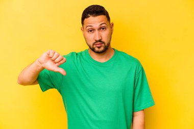 Sarı arka planda izole edilmiş, hoşlanmadığı bir hareket gösteren genç bir İspanyol. Anlaşmazlık konsepti.