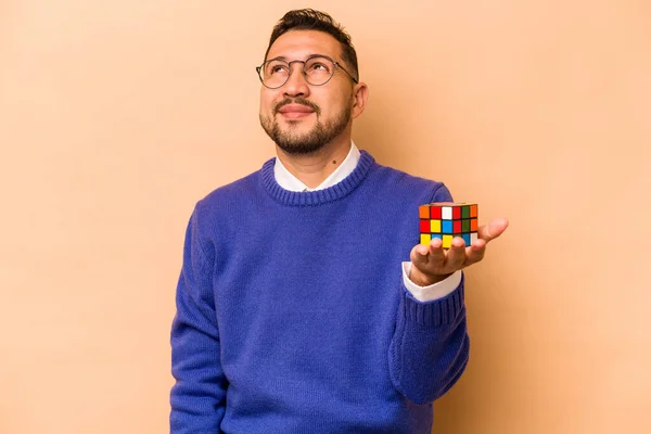 Hispánec Drží Rubikovu Kostku Izolovanou Béžovém Pozadí Sní Dosažení Cílů — Stock fotografie
