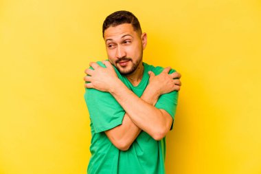 Genç İspanyol adam sarı arka planda yalnızdı. Sarılmalar, kaygısız gülümsemeler ve mutluluklar..