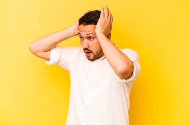 Genç İspanyol adam sarı arka planda izole edilmiş bağırıyor, çok heyecanlı, tutkulu, bir şeyden memnun..