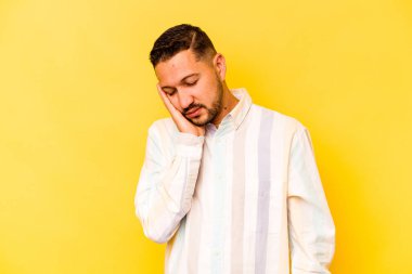 Sarı arka planda izole edilmiş genç bir İspanyol. Sıkılmış, yorgun ve dinlenmeye ihtiyacı var..