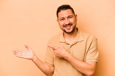 Latin kökenli genç, bej arka planda izole edilmiş..