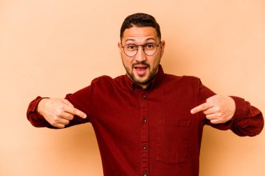 Latin kökenli genç adam bej arka planda izole edilmiş..