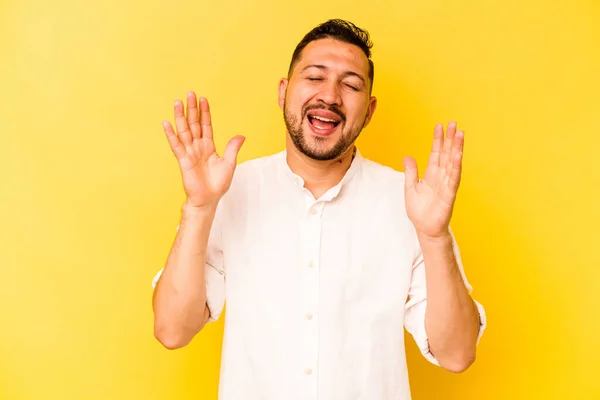 Mladý Hispánec Muž Izolovaný Žlutém Pozadí Hlasitě Směje Držet Ruku — Stock fotografie
