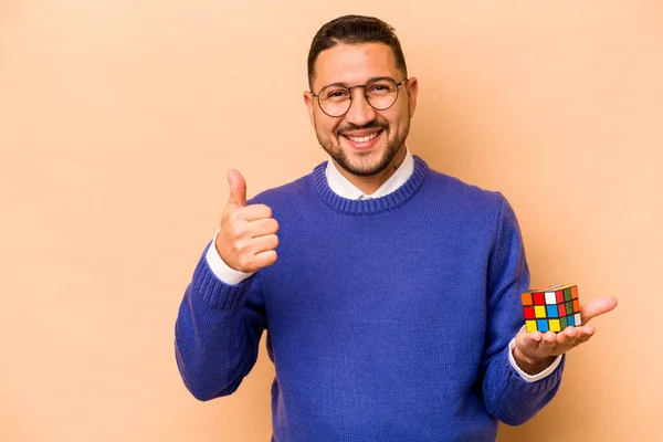 Hispanic Man Holding Rubik Cube Isolated Beige Background Smiling Raising — Stock fotografie