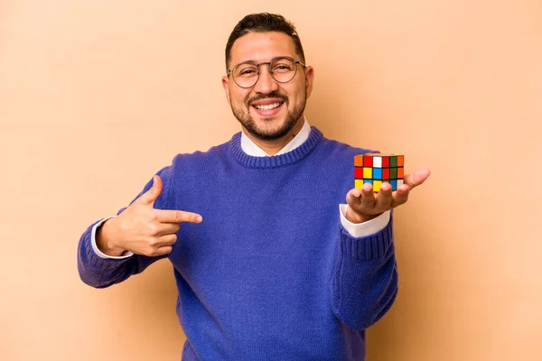 Hispanic Man Holding Rubik Cube Isolated Beige Background Person Pointing — Stock fotografie