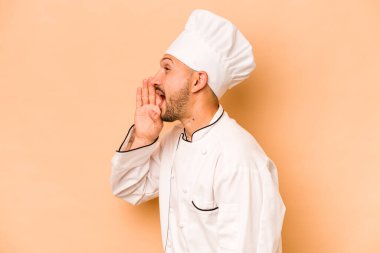 İspanyol aşçı bej arka planda izole edilmiş bağırıyor ve avuç içini açık tutuyor..