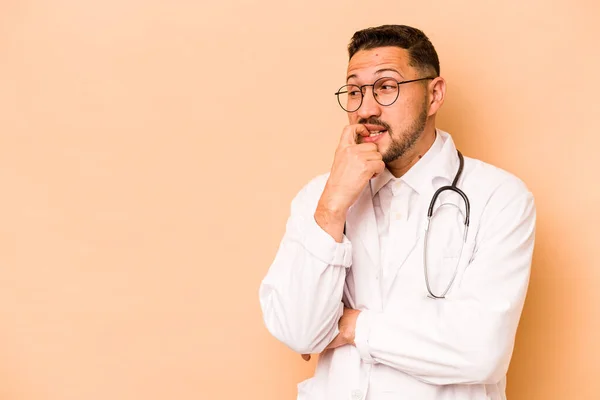 Hispanic Doctor Man Isolated Beige Background Relaxed Thinking Something Looking — Stockfoto