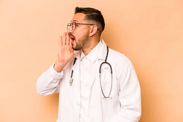 Hispanic Doctor Man Isolated Beige Background Shouting Holding Palm Opened — Zdjęcie stockowe