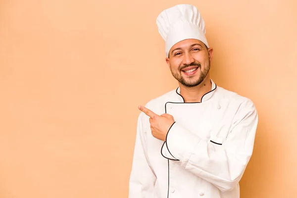 Hispanic Chef Man Isolated Beige Background Smiling Pointing Aside Showing — Stockfoto
