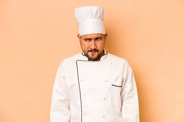 Hispanic Chef Man Isolated Beige Background Confused Feels Doubtful Unsure — Zdjęcie stockowe