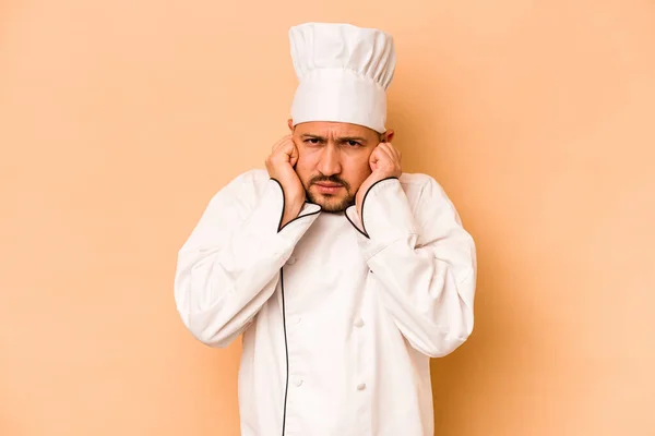 Hispanic Chef Man Isolated Beige Background Covering Ears Hands — Zdjęcie stockowe