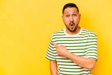 Sarı arka planda izole edilmiş genç bir İspanyol yan tarafı işaret ediyor.