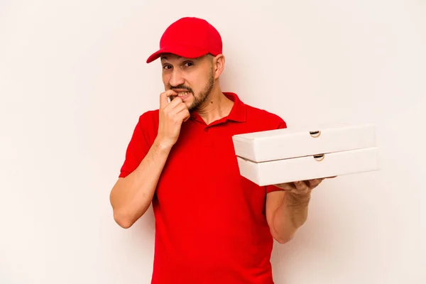 Młody Dostawca Trzyma Pizzę Beżowym Tle Obgryzając Paznokcie Nerwowy Bardzo — Zdjęcie stockowe