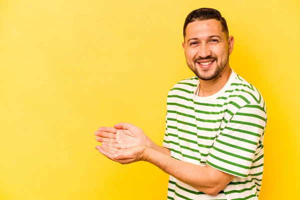 Mladý Hispánec Muž Izolovaný Žlutém Pozadí Držící Kopii Prostoru Dlani — Stock fotografie