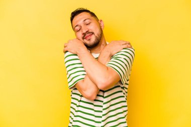 Genç İspanyol adam sarı arka planda yalnızdı. Sarılmalar, kaygısız gülümsemeler ve mutluluklar..