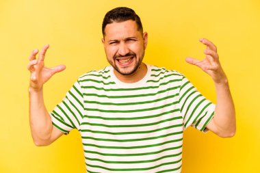 Sarı arka planda izole edilmiş genç bir İspanyol öfkeyle bağırıyor..