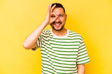İspanyol asıllı genç adam sarı arka planda izole edilmiş. Heyecanlı..