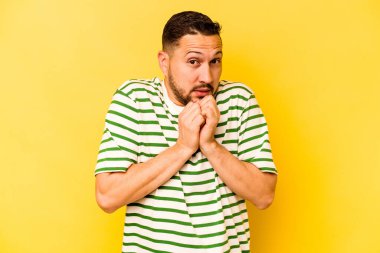 Genç İspanyol adam sarı arka planda izole edilmiş korkmuş ve korkmuş..