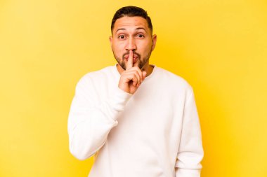 Sarı arka planda izole edilmiş genç bir İspanyol ya sır saklıyor ya da sessizlik istiyor..