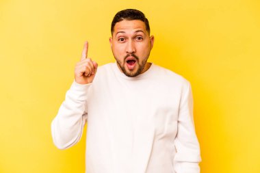 Sarı arka planda izole edilmiş genç İspanyol bir adamın bir fikri, ilham konsepti var..