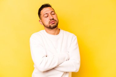 Sarı arka planda izole edilmiş genç İspanyol adam tekrarlanan bir görevden yoruldu..