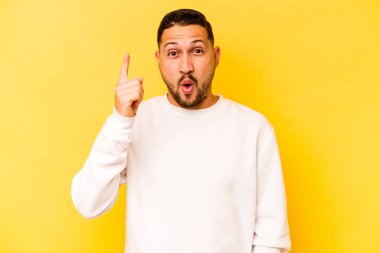 İspanyol asıllı genç adam sarı arka planda izole edilmiş. Harika bir fikri var. Yaratıcılık kavramı..