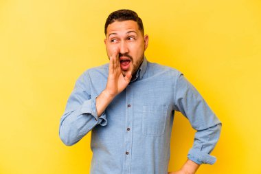 Sarı arka planda izole edilmiş genç İspanyol adam heyecanla bağırıyor.