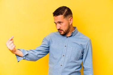 Sarı arka planda izole edilmiş genç bir İspanyol seni işaret ediyor sanki davet ediyormuş gibi..