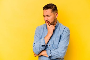 Sarı arka planda izole edilmiş genç bir İspanyol ya sır saklıyor ya da sessizlik istiyor..