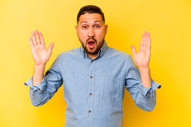 Sarı arka planda izole edilmiş genç İspanyol bir adamın bir fikri, ilham konsepti var..