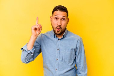 İspanyol asıllı genç adam sarı arka planda izole edilmiş. Harika bir fikri var. Yaratıcılık kavramı..