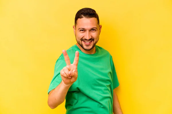 Молодий Іспаномовний Чоловік Ізольований Жовтому Тлі Показуючи Знак Перемоги Посміхаючись — стокове фото