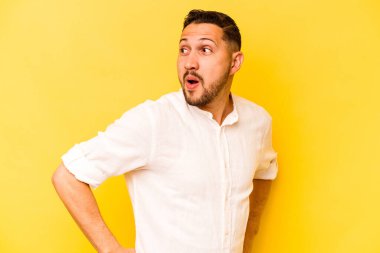 Sarı arka planda izole edilmiş genç bir İspanyol. Gülümsüyor, neşeli ve keyifli görünüyor..