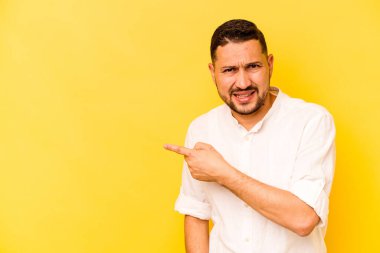 Sarı arka planda izole edilmiş genç bir İspanyol yan tarafı işaret ediyor.