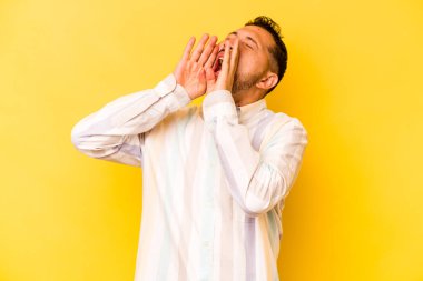 Sarı arka planda izole edilmiş genç İspanyol adam heyecanla bağırıyor.