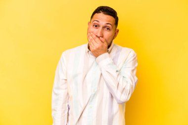 Genç İspanyol adam sarı arka planda izole edilmiş korkmuş ve korkmuş..