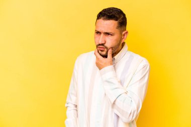 Sarı arka planda izole edilmiş genç İspanyol bir adam virüs veya enfeksiyon yüzünden boğaz ağrısı çekiyor..