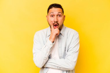 İspanyol asıllı genç adam sarı arka planda izole edilmiş. Harika bir fikri var. Yaratıcılık kavramı..