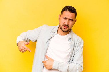 Sarı arka planda karaciğer ağrısı çeken, karnı ağrıyan genç bir İspanyol..