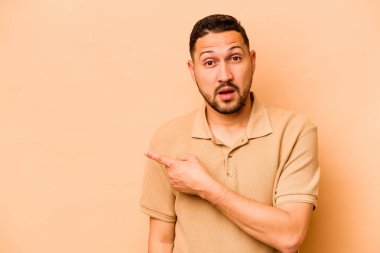 Latin kökenli genç adam bej arka planda izole edilmiş.