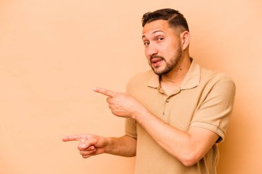 Latin kökenli genç adam bej arka planda izole edildi..