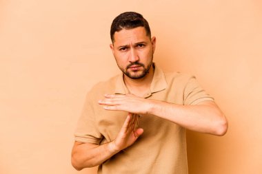 Latin kökenli genç bir adam bej arka planda izole edilmiş..