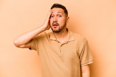 Latin kökenli genç bir adam, bej arka planda izole edilmişti..