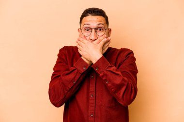 Latin kökenli genç adam bej arka planda izole edildi..