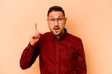Latin kökenli genç bir adam bej arka planda izole edilmiş. Bir fikri var, ilham verici bir kavram..